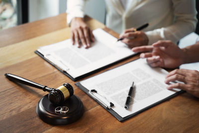 Midsection of man reading book on table