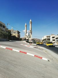 Road by building against clear sky