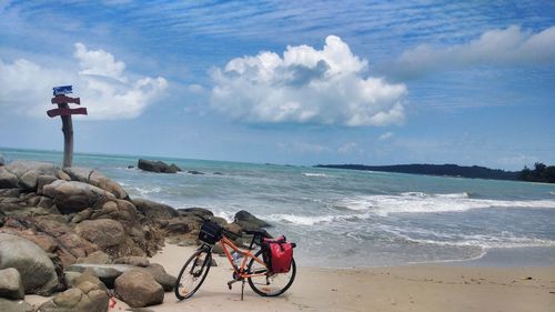 Bicycle on beach against sky