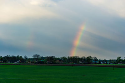 Scenic view of rainbow over landscape against sky