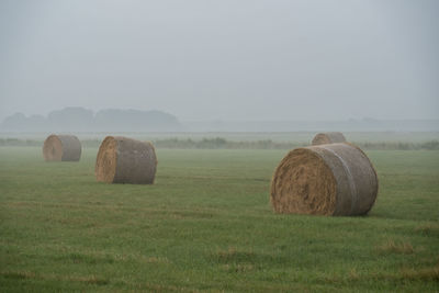 Hay bales on field against sky