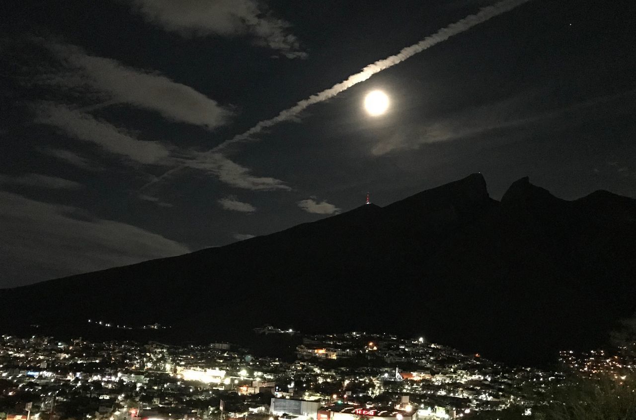 LOW ANGLE VIEW OF ILLUMINATED CITY AGAINST SKY