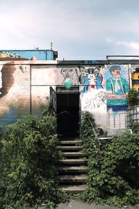 Low angle view of graffiti on building against sky