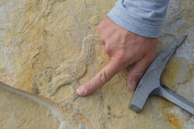 Close-up of man pointing at concrete