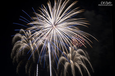 Low angle view of firework display at night