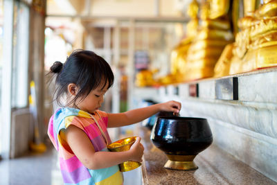 Girl holding ice cream in kitchen