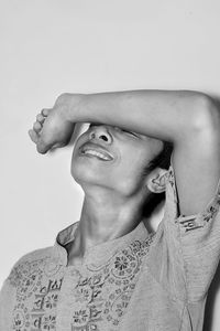 Portrait of smiling young woman against white background