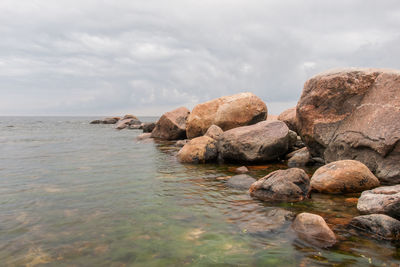 Rocks on sea shore against sky