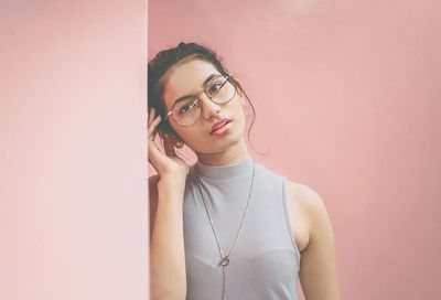 Portrait of beautiful young woman against gray background