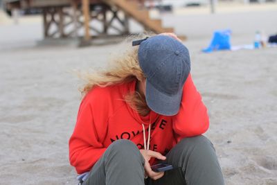 Woman using her phone not paying attention to her surroundings at the beach distracted by technology