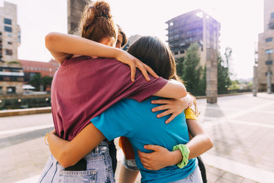 Friends hugging each other on sunny day