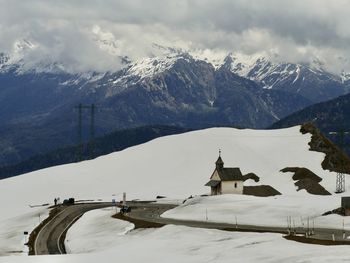 Built structure on snowcapped mountain against sky