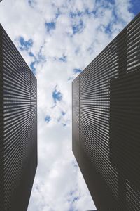 Low angle view of modern building against cloudy sky