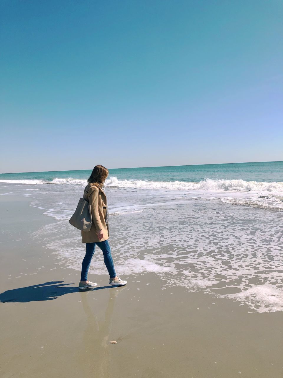 sea, horizon over water, beach, nature, water, one person, beauty in nature, shore, clear sky, real people, scenics, full length, leisure activity, vacations, rear view, wave, sky, sunlight, day, sand, standing, lifestyles, outdoors, weekend activities, ankle deep in water, people