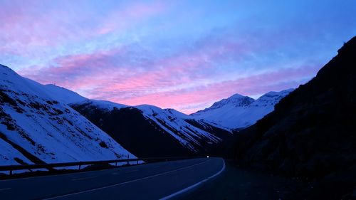 Scenic view of snowcapped mountains against sky during sunset