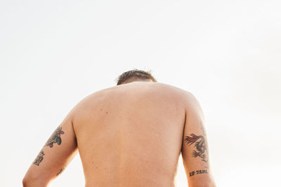 Rear view of shirtless man against white background