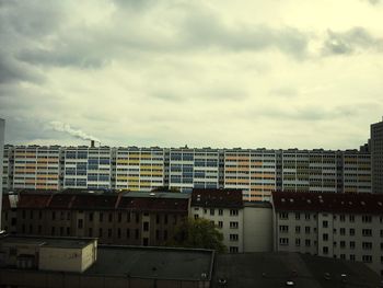 Buildings against cloudy sky