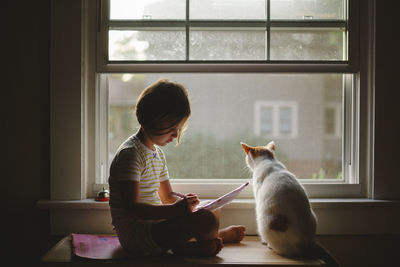 Side view of man with cat at home