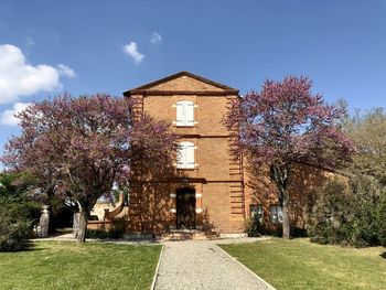 Exterior of building by tree against sky