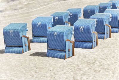 Hooded chairs on sand at beach