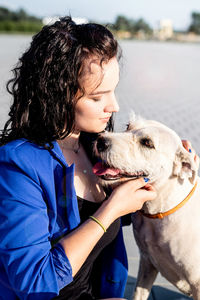 Close-up of young woman playing with dog