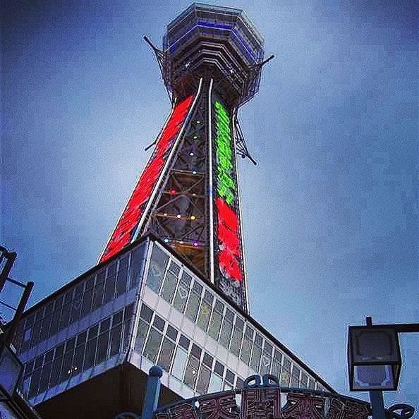 low angle view, built structure, architecture, clear sky, building exterior, sky, red, blue, tall - high, tower, arts culture and entertainment, outdoors, no people, flag, travel destinations, amusement park, copy space, day, famous place, tall