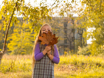 Close-up of girl holding autumn leaves