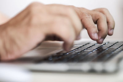 Cropped hands of person using keyboard