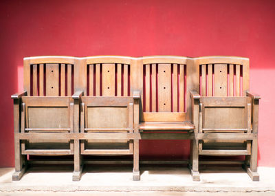 Empty wooden chairs against wall