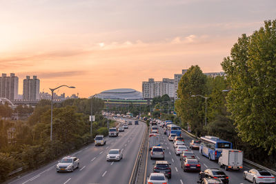 Cars on street against sky during sunset