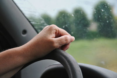 Cropped hand of person driving car