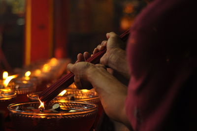 Cropped hands of man holding burning incense