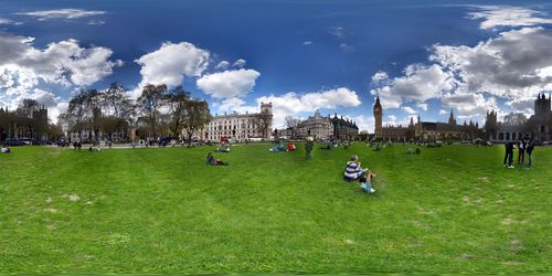 People relaxing on grassy field in park