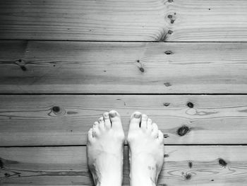 Low section of woman standing on wooden floor