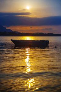 Boat in sea at sunset