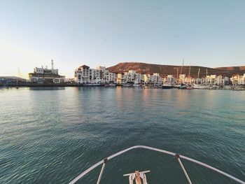 Scenic view of sea by buildings against clear sky