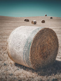 Hay bales on field against sky