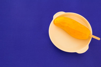 High angle view of yellow slices against blue background