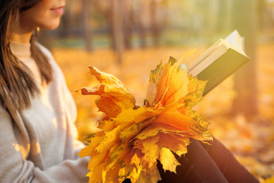 Young woman holding autumn leaves