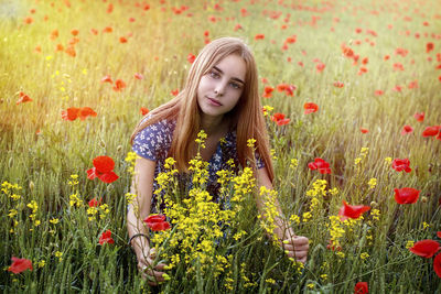 Full length of teenage girl in flower field