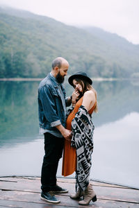 Rear view of couple standing by lake