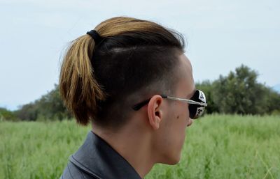 Close-up of boy wearing sunglasses on field against clear sky