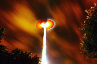 Low angle view of illuminated trees against sky at night