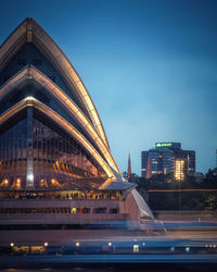 Illuminated modern buildings against sky at night