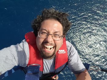 High angle view portrait of smiling man parasailing over sea