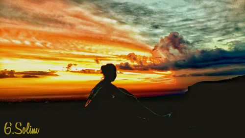 Woman on rock against sky during sunset