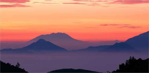 Scenic view of mountains against sky at sunset