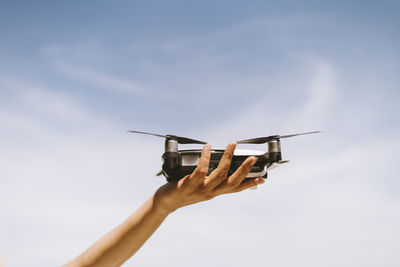 Low angle view of person hand against sky