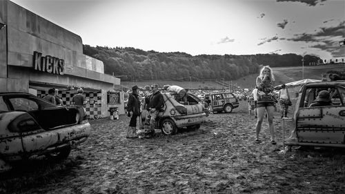 Rear view of people on street against sky