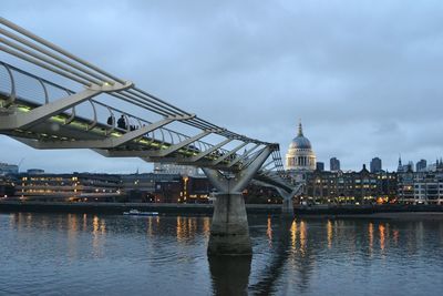 Bridge over river against cloudy sky